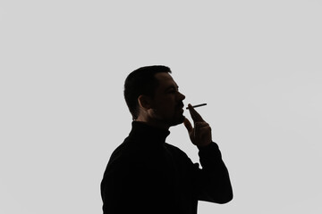 Silhouette of smoking man on light background