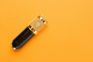 Modern microphone on orange background