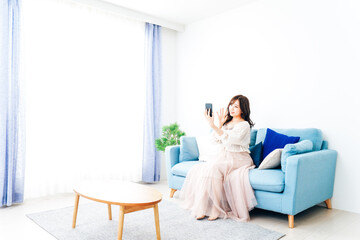 スマートフォンでライブ配信をする若い女性