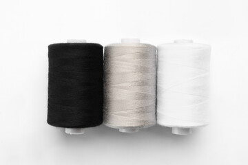 Multicolored sewing thread spools on white background