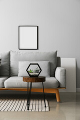 Interior of modern living room with stylish sofa, table and photo frame