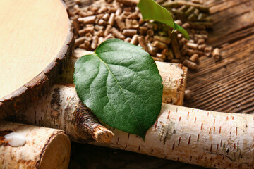 Pile of wood pellets and leaf on wooden background, closeup
