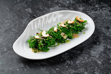 Plate with tasty seaweed salad on table