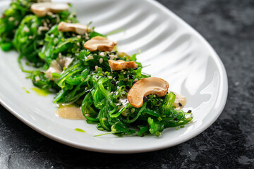 Plate with tasty seaweed salad on table