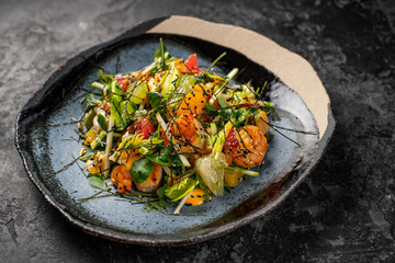 Refreshing salad with pomelo, shrimps, carrots and cashew nuts on a light blue background. Asian cuisine. Food collage