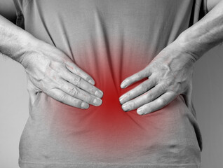 Lower back pain. Man hands holding red painful spot closeup. Sedentary lifestyle, injury, chronical illness, inconvenient posture. High quality photo