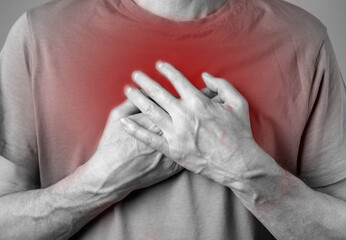 Man suffering from solar plexus pain. Hand holding red painful point closeup. Health care, medicine...