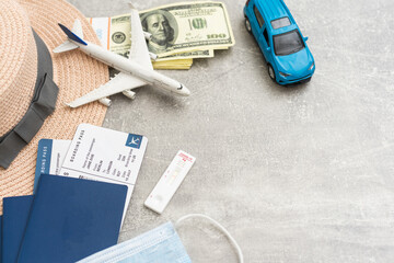 Syringe, toy plane, medical mask and passport with certificate of vaccination with text 'Covid-19 Vaccinated' inside it. Travel concept during the Covid-19 pandemic.