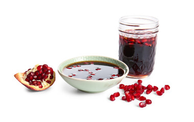Bowl and jar of pomegranate molasses with fresh fruits on white background