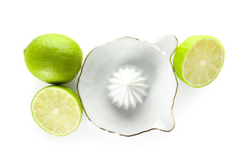 Ceramic juicer and limes on white background