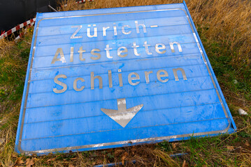 Blue vintage direction road sign laying on the ground at City of Zürich on a cloudy spring day....