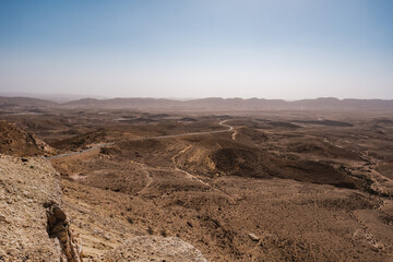Beautiful scenery of dry desert with rough rocky cliffs on the background of blue sky