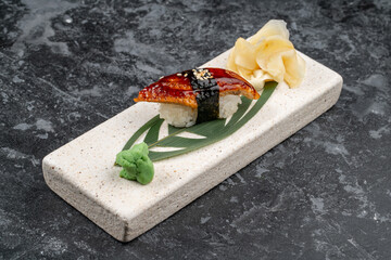 Fototapeta na wymiar Smoked nigiri sushi eel, unagi sauce, sesame seeds isolated on black background