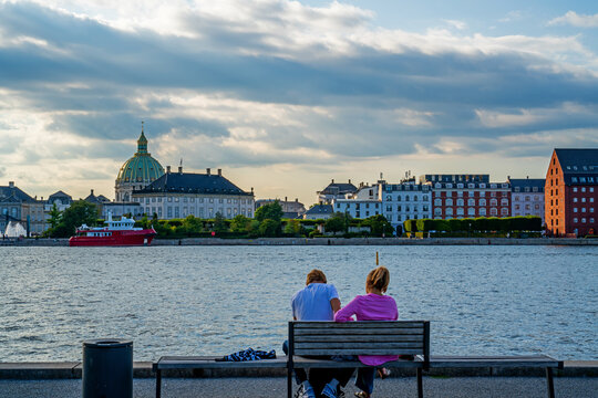 Young couple sitting by the harbor of Copenhagen, Denmark
