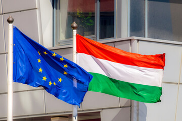 The flags of the European Union and Hungary are waving in the wind
