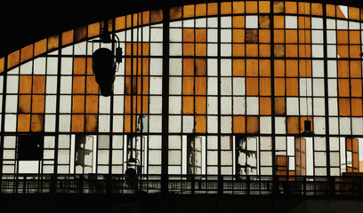 Abstract image and silhouette of train station roof. There are white and yellow glass. It looks quite old and worn out.
