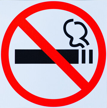 Black burning cigarette in forbidding crossed out red circle on white background. The sign, logo, embleme or simbol of no smoking area or zone