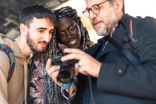 Photographer swows photos to their models on camera &ndash; berd man with camera in hand &ndash; photographer looking photo on camera 