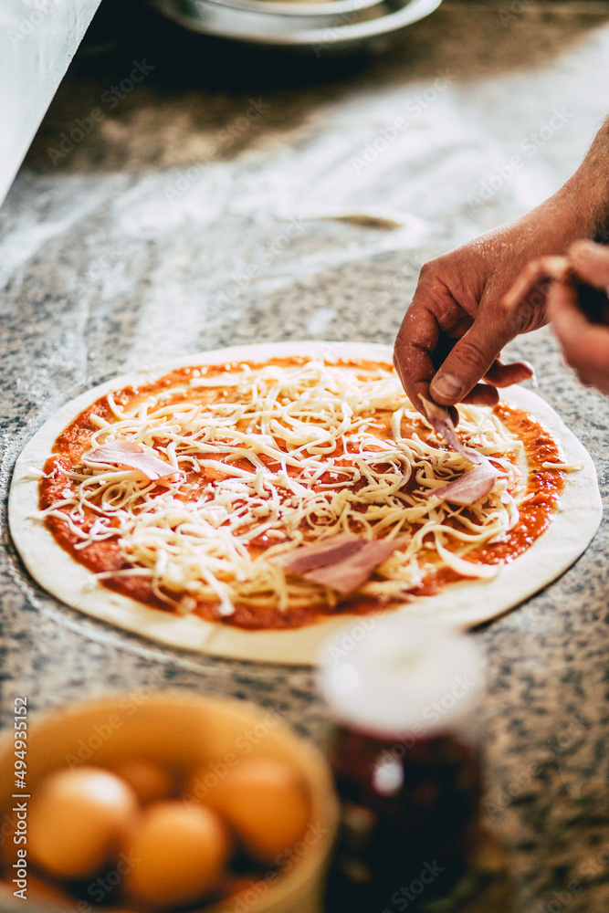 Wall mural closeup of a man preparing a pizza