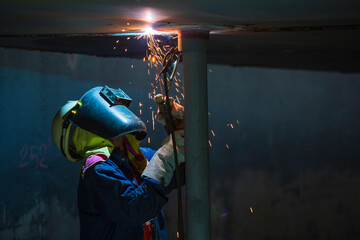 Welding male worker metal is part of machinery plate roof tank beam construction flash spark.