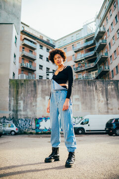 Young mixed race curly hair fashionable woman posing outdoor