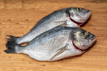 Gilt-head bream fresh raw fish dorada without scales and gills, ready for cooking. Picture of dorade for the fish seafood market menu