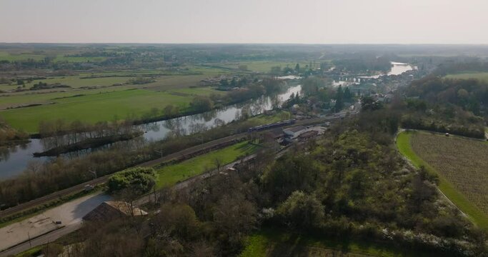 Aerial shot of a train driving next to the valley of Le Cher in Montrichard, France.