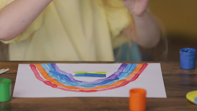 No war. Little girl draws a picture about Ukraine. Draws a rainbow and the Ukrainian flag