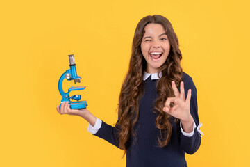 happy winking child hold microscope for school education show ok gesture, back to school.