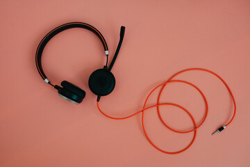 black headphone over pink color background,copy space.
