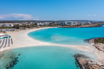 Nissi Beach in Ayia Napa, clean aerial photo of famous tourist beach in Cyprus, the place is a known destination on island and is formed from a smaller island just near the main shore