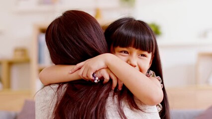 Close up cute little girl face embraces mother, expressing gratitude and love caring smile. Happy mother hugs daughter. A beautiful mom and her adorable little daughter are hugging and smiling.