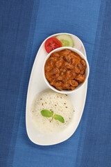 Rajma Or Razma is a popular North Indian Food, consisting of cooked red kidney beans in a thick gravy with spices. Served in bowl with Jeera Rise & green salad