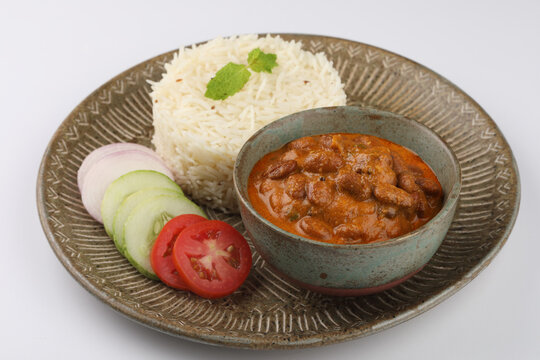 Rajma Or Razma is a popular North Indian Food, consisting of cooked red kidney beans in a thick gravy with spices. Served in bowl with Jeera Rise & green salad