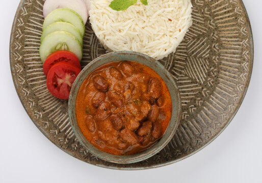 Rajma Or Razma is a popular North Indian Food, consisting of cooked red kidney beans in a thick gravy with spices. Served in bowl with Jeera Rise & green salad