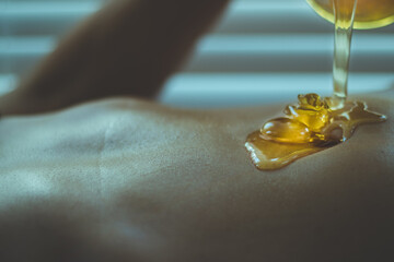 Closeup shot of honey on human skin on a blurred background