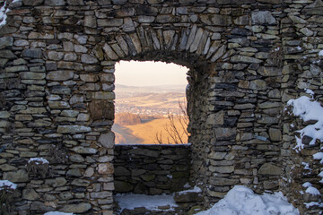 looking at a landscape through old stone window of a castle ruin