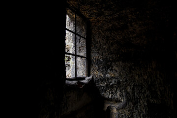 window in the dark in an old abandoned stone building