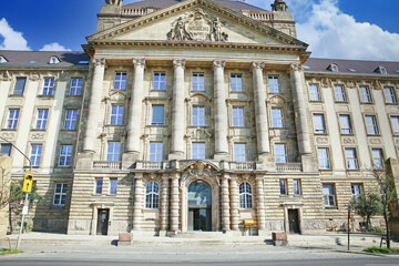 Fototapeta na wymiar Düsseldorf (Bezirksregierung), Germany - March 21.2022: View on neo baroque front facade of local gevernment president palace against blue sky, fluffy clouds