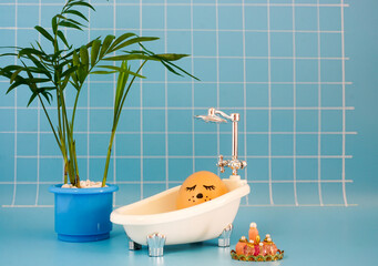 Egg takes a bath in a blue bathroom with a palm tree. Creative Easter photography. 