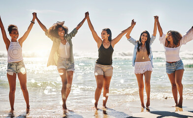 Summer was made for days like this. Shot of a group of cheerful friends holding hands on the beach. - Powered by Adobe
