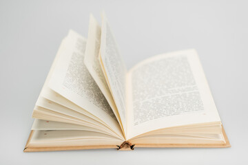 open book with text on grey blurred background.