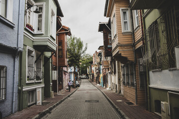 old vintage narrow street and some wooden historical colourfull houses, walking man