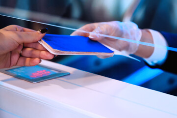 Passenger giving his documents for check-in to airport manager by counter