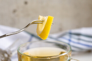 Slice of chopped lemon on a green tea fork. Green tea with lemon.
