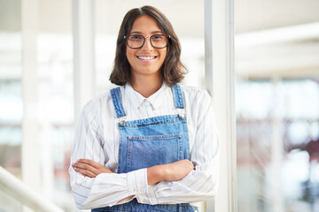 Its the coolest company to work for. Portrait of a confident young businesswoman working in a modern office.