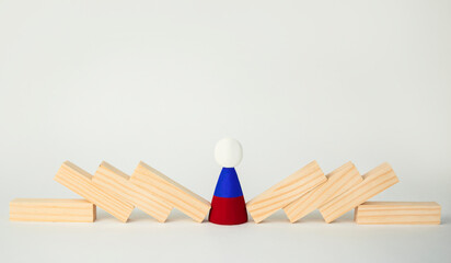 The concept of the domino effect, the fall of the Russian economy. A wooden man with the symbol of...