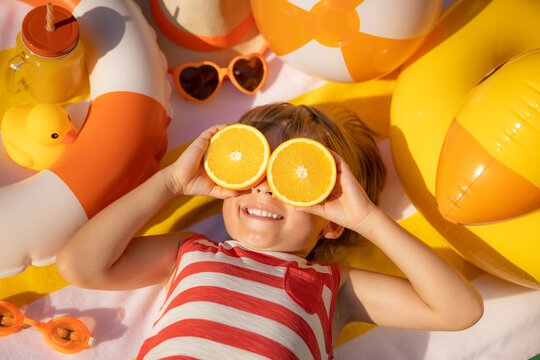 Naklejki Happy child lying on beach towel