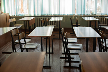 Desks for students at school. Classroom is empty. Chairs and tables are in row.