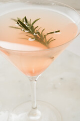 Close-up of grapefruit cocktail with a  rosemary